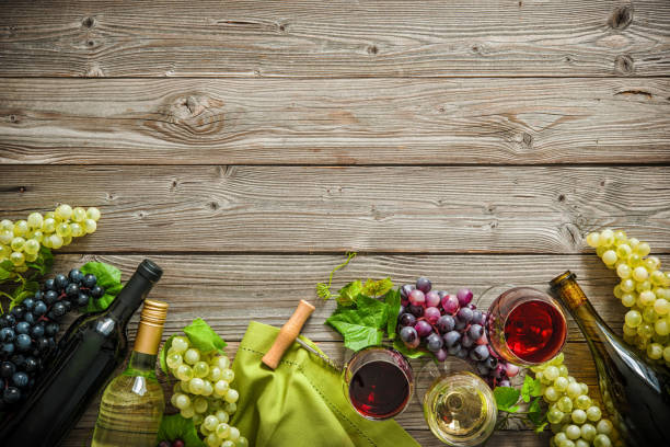 istock Wine bottles with grapes and corks on wooden background 695995454