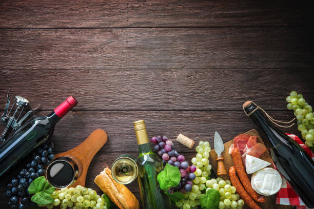 Wine bottles with grapes, cheese, ham and corks