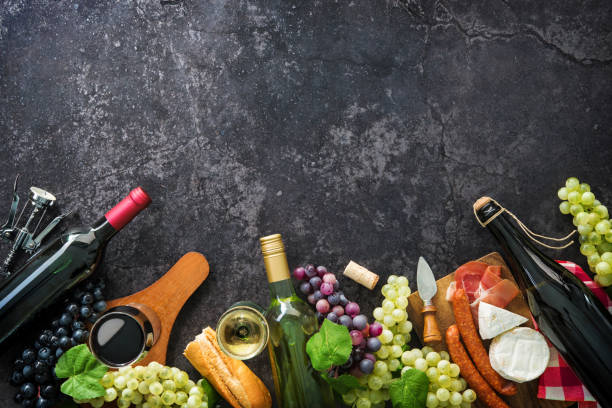 istock Wine bottles with grapes, cheese, ham and corks 695998574