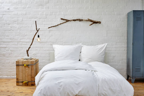 istock vintage loft white brick wall bed and birch branches 696009736