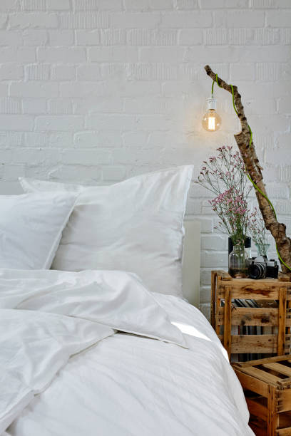 istock white bed linen creative night stand industrial loft brick wall 696009882