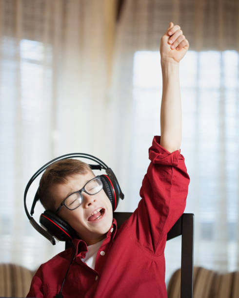 istock Cute boy listening and singing a song with emotions 696010064