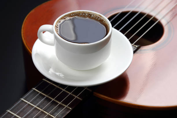 istock white cup with black coffee lying on the acoustic guitar 696032660