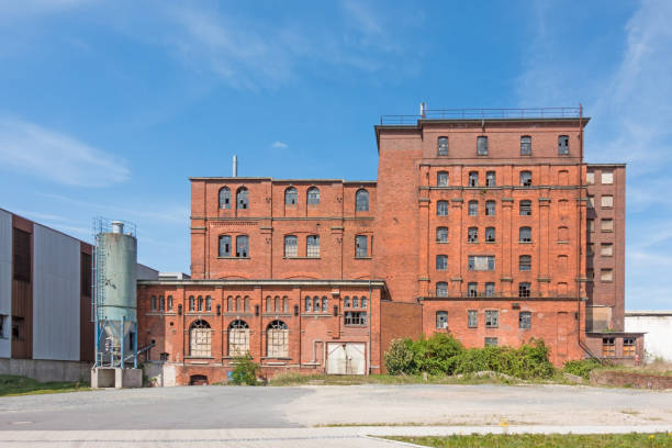 außenansicht eines verfallenen fabrikgebäudes aus ziegelsteinen gebaut - alte fabrik stock-fotos und bilder