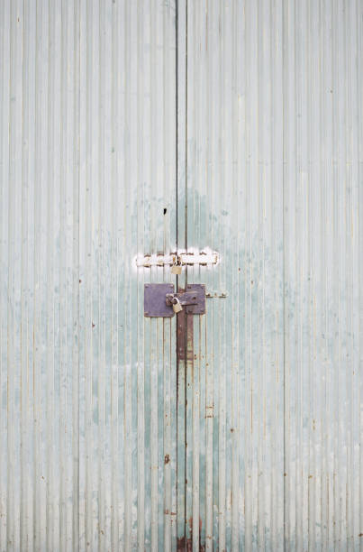 Metal door lock Metal door lock on industrial building protection corrugated metal fence ideas stock pictures, royalty-free photos & images