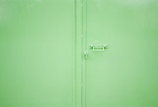 Green Industrial door Green industrial metal door in building corrugated metal fence ideas stock pictures, royalty-free photos & images