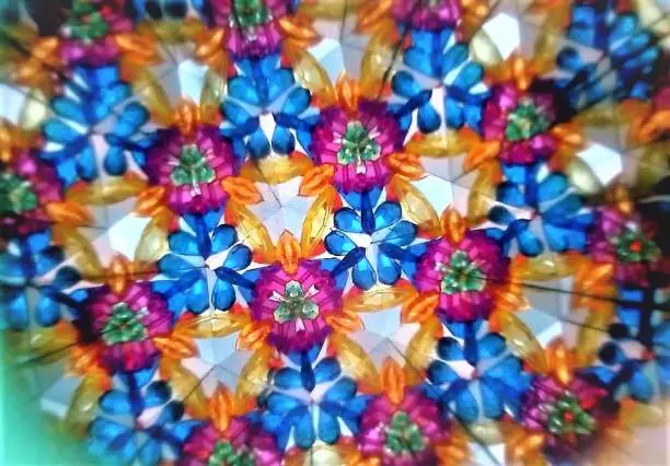 Close-up of a kaleidoscope image.  Blue, White, purple, orange color.