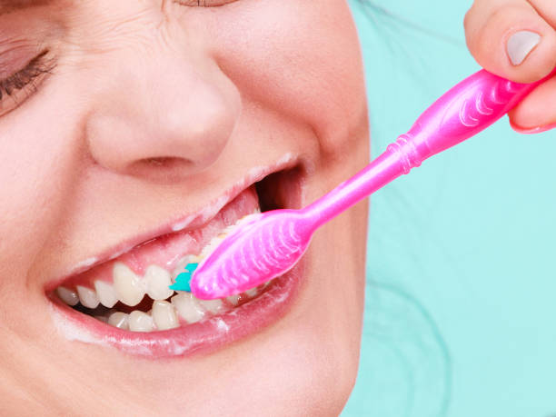 istock Woman brushing cleaning teeth 696048536