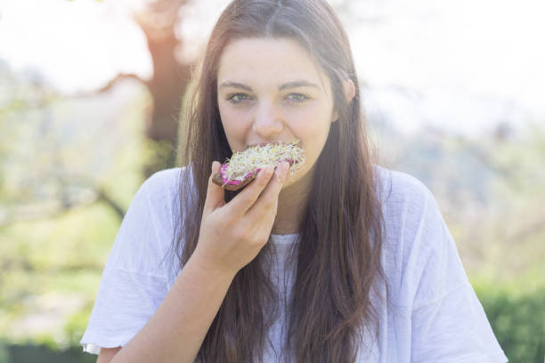 istock Young woman eating sandwich 696055302