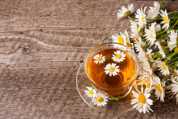 istock Herbal tea with fresh chamomile flowers on old wooden background with copy space for your text 696056542