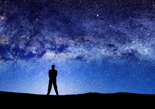 conceptual image of silhouetted man and abstract universe lights. NASA galaxy images manipulated and used; https://nasasearch.nasa.gov/search/images?utf8=%E2%9C%93&affiliate=nasa&query=galaxy+images