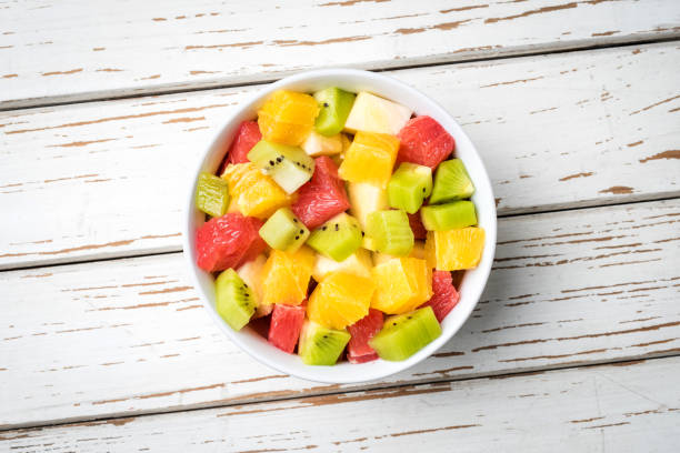 istock Fresh fruit salad on an old white wooden table 696063726