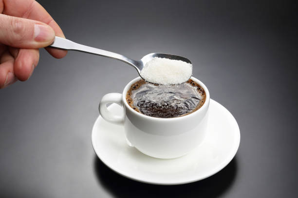 istock white cup with black coffee and spoon with sugar 696070408