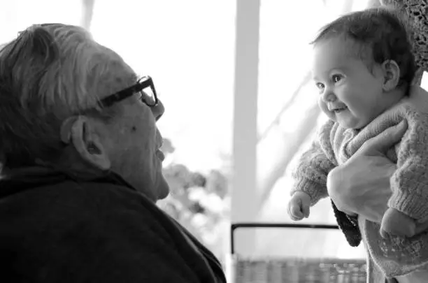 Great Granddad hugs his great grandchild during a home visit.