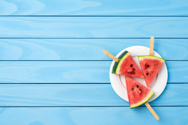 istock Watermelon slices on blue wooden table. 696071114