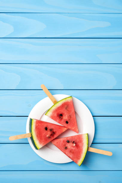 istock Watermelon slices on blue wooden table. 696071270