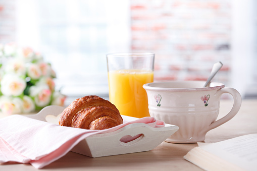 Croissants, coffee and orange juice on table.