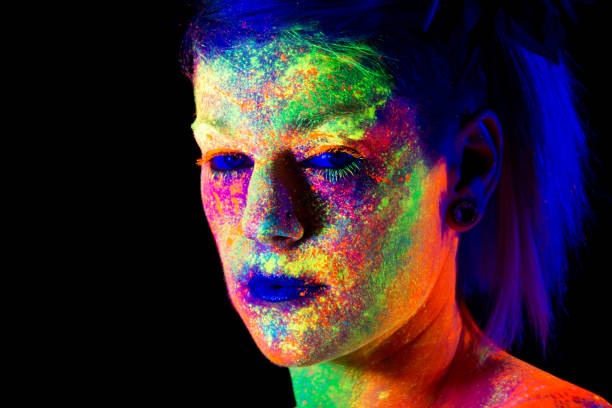 istock Closeup of model in multicoloured UV face paint with spooky blue eyes 696081610