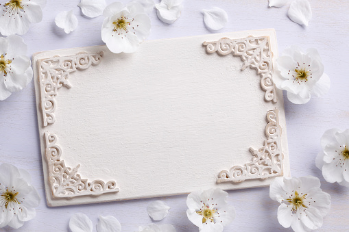 Vintage carved white wooden sign with flowers.