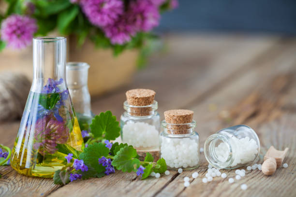 Vials of tincture or infusion of healthy herbs, bottles of homeopathy globules and healthy herbs on table. Alternative medicine concept. Vials of tincture or infusion of healthy herbs, bottles of homeopathy globules and healthy herbs on table. Alternative medicine concept. homeopathic medicine photos stock pictures, royalty-free photos & images