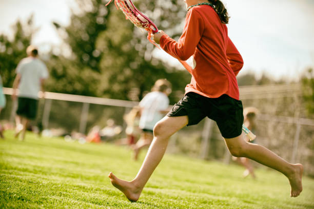 istock girl playing and running during lacrosse 696090824