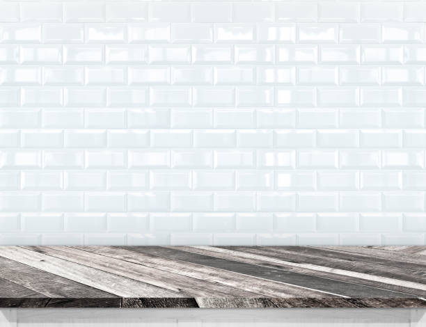 istock Empty diagonal wood plank table top with glossy ceramic white tile wall,Mock up for display or montage of product 696091152