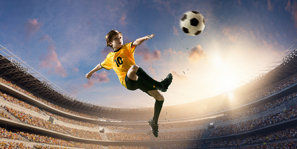 Soccer kids player in action in 3D dramatic stadium. He is dressed in a professional football uniform. Behind him is a stadium with fans in the stands.
