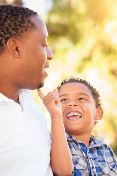istock Mixed Race Son and African American Father Playing Outdoors Together. 696100736