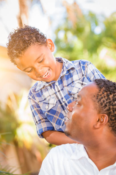 istock Mixed Race Son and African American Father Playing Outdoors Together. 696100766