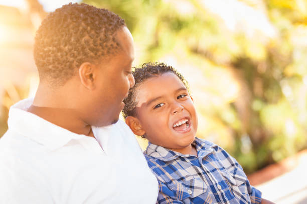 istock Mixed Race Son and African American Father Playing Outdoors Together. 696103032