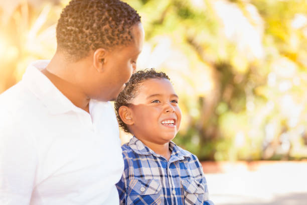 istock Mixed Race Son and African American Father Playing Outdoors Together. 696103156