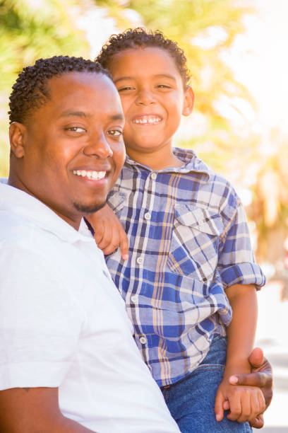 istock Mixed Race Son and African American Father Playing Outdoors Together. 696103192