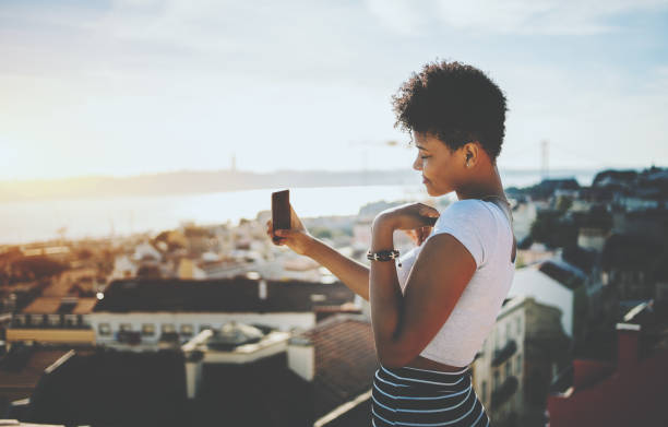 istock Black girl is making selfie with cityscape in background 696107634