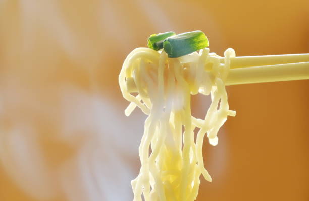 istock Chinese egg noodles picking in chopsticks with smoke 696108432