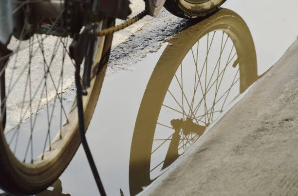 istock bicycle wheel reflection in water flood 696108548