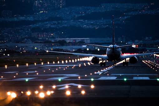 A big plane arriving at the airport at night.