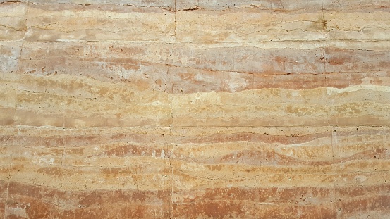 Textures and design by nature of a rammed earth wall.Cracks in the wall. Nature orange background.wallpaper,copy space