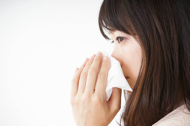 istock Young woman blowing her nose 696120740