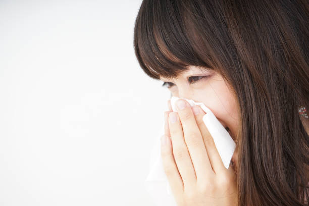 istock Young woman blowing her nose 696120742