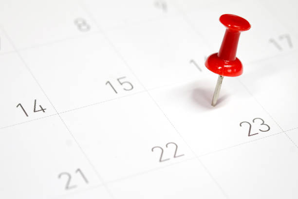 pinos de vermelhos bordados em um calendário no dia 23 com foco seletivo - calendar calendar date reminder thumbtack - fotografias e filmes do acervo