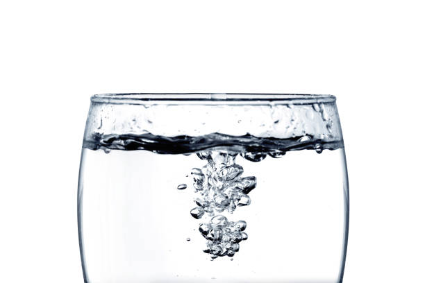 istock pouring water into a glass closeup isoleted on white background with Clipping path 696130360