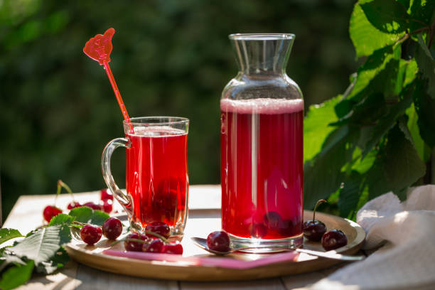 istock Homemade sour cherry compote in glass cup with jar on bamboo tray 696133868