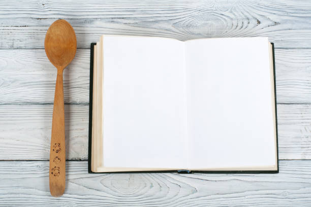 istock Recipe cook blank book on wooden background, spoon, rolling pin, checkered tablecloth 696134598