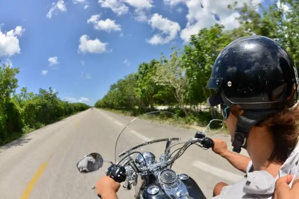 A young man drives a Harley fast in Cozumel, Mexico.