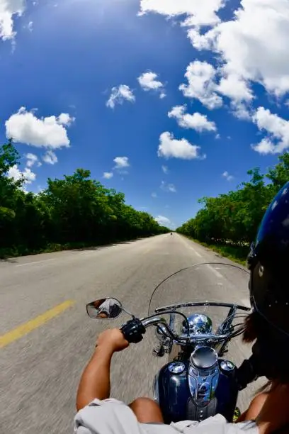 A young man drives a Harley fast in Cozumel, Mexico.