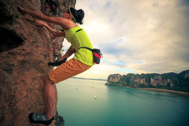 istock young woman rock climber climbing on cliff 696152540