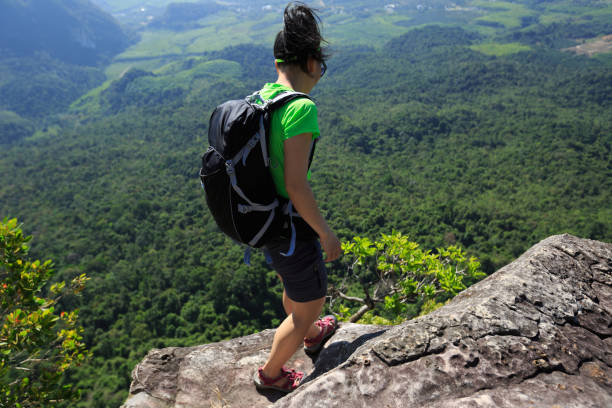 istock young woman backpacker enjoy the view on mountain top cliff 696158912