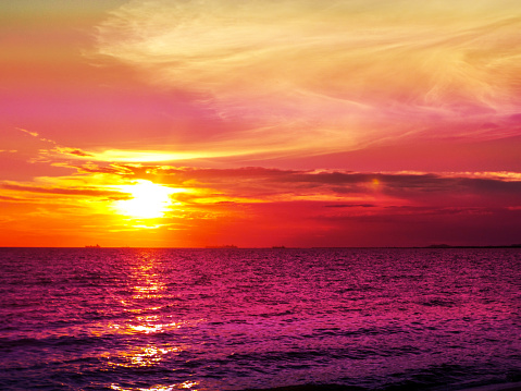 Sunset and cloud on horizon purple water