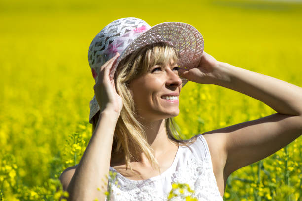 istock Young woman with a hat enjoying summer on the rape field 696162866