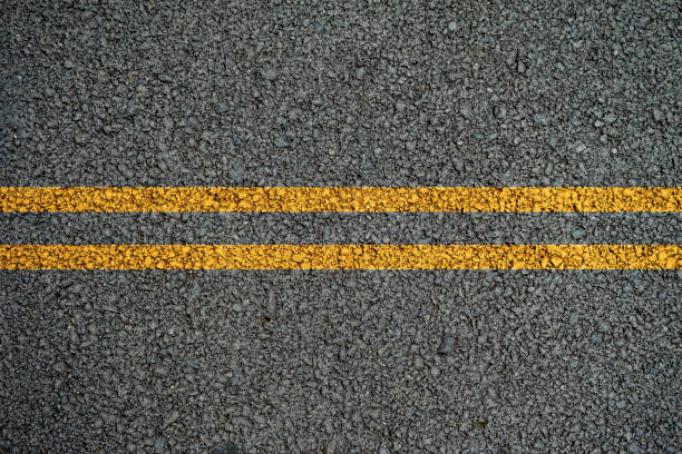 double yellow lines on the asphalt road in the middle. - two lane highway fotos imagens e fotografias de stock